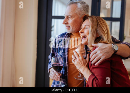 Blonde-haired woman feeling extremely happy with her husband Stock Photo