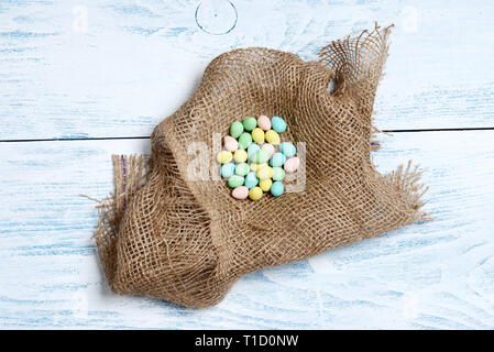 Burlap nest with colorful easter eggs Stock Photo
