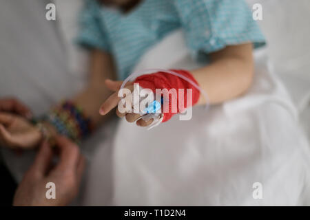 Details with a cannula on the hand of a ill little girl in a pediatric hospital reserve Stock Photo