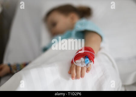 Details with a cannula on the hand of a ill little girl in a pediatric hospital reserve Stock Photo