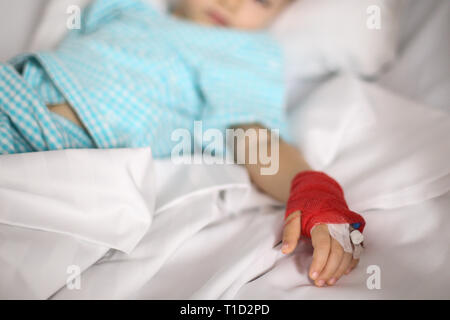 Details with a cannula on the hand of a ill little girl in a pediatric hospital reserve Stock Photo