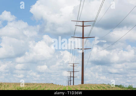 High Voltage Power Lines in Field with Cumulus Clouds Stock Photo