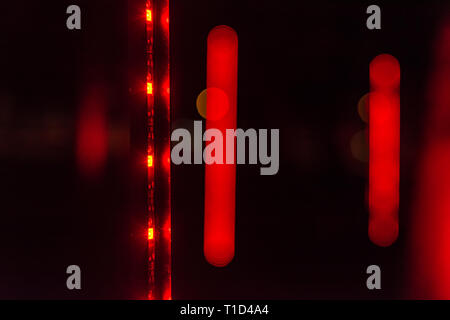 Red lights in the dark. Abstract red and black glowing background. Flickering red lights on black background. Stock Photo