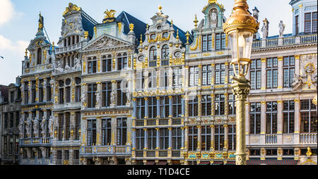 Vintage street lamp in front of rich sculptural decorated guild houses facades on The Grand Place of Brussels, Belgium. Lavishly designed gables are b Stock Photo