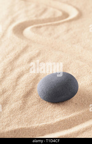 Zen stone Japanese sand garden round rock in sand. Buddhism or yoga background for spiritual purity and concentration. Stock Photo