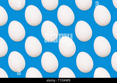White eggs on a blue background. Many eggs arranged in a row. Stock Photo