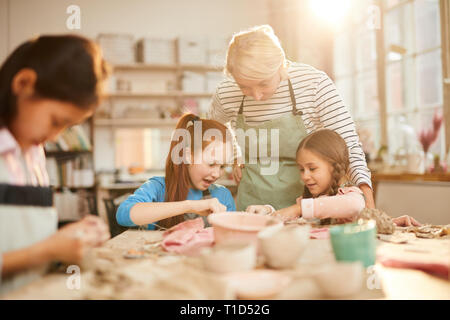 Female Art Teacher Working with Kids Stock Photo