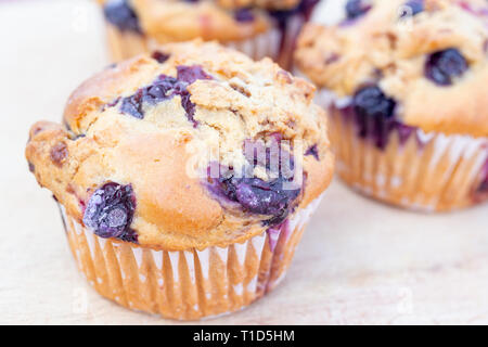 Homemade vegan blueberry muffin presented on a wooden plate Stock Photo