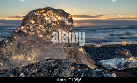 Sun Shining Through Iceberg on Jokulsarlon Iceberg Beach (aka Diamond Beach), Iceland Stock Photo
