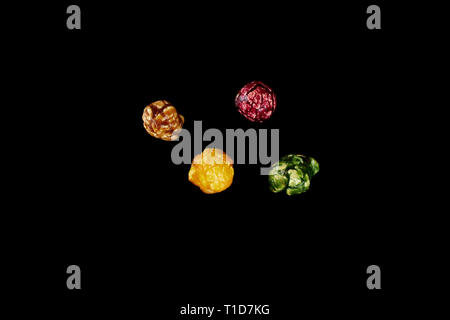 multicolored caramel popcorn on a black background. Stock Photo