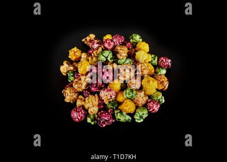 multicolored caramel popcorn on a black background. Stock Photo