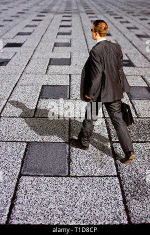 man in suit and briefcase walking Stock Photo