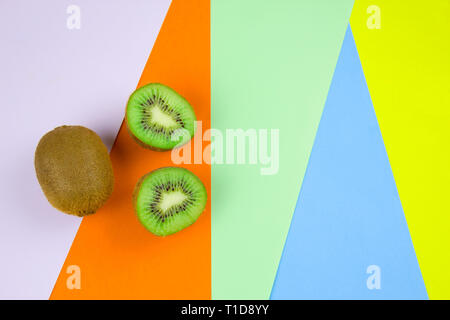 top view kiwi fruit on a vibrant multicolored stripped background Stock Photo