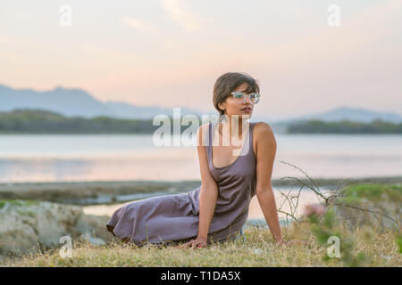 Model in a dress by Udaipur lake at sunset in Rajasthan, India. Stock Photo