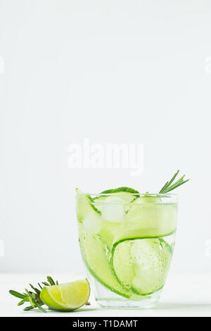 Drink from fresh cucumber juicy lime and a sprig of rosemary in glass goblet white background. Summer refreshing detox. Stock Photo