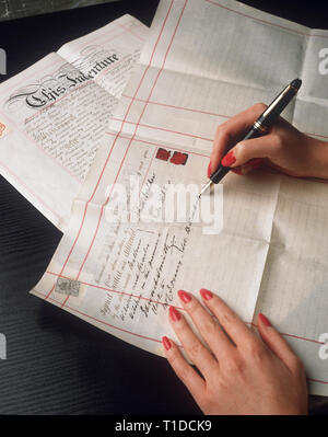 Pair of female hands signing documents Stock Photo