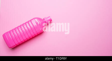 Fabric softener blank no name bright pink color on pink background, top view, copy space. Laundry concept. Stock Photo