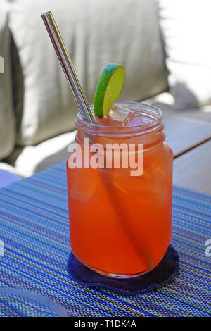 Drinking a pink strawberry lemonade in a mason jar with a straw Stock Photo