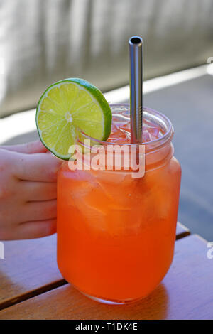 Drinking a pink strawberry lemonade in a mason jar with a straw Stock Photo
