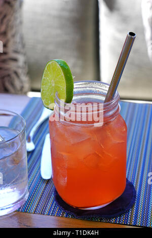 Drinking a pink strawberry lemonade in a mason jar with a straw Stock Photo