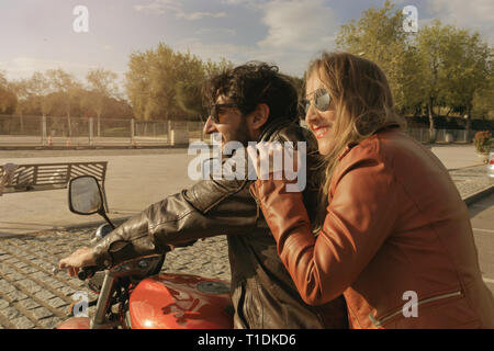 Couple of motorcyclists on a retro style motorbike, watching the sunset in Spain Stock Photo