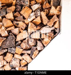 A stack of fire wood leaned against the white walls of a cottage Stock Photo