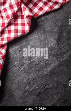 Top of view red checkered tablecloth on black slate board. Stock Photo