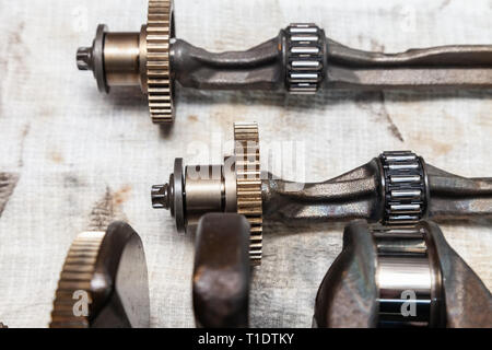 Close-up on a car shaft with gears and bearings removed for replacement on a workbench in a repair shop for vehicles. Auto service industry. Stock Photo