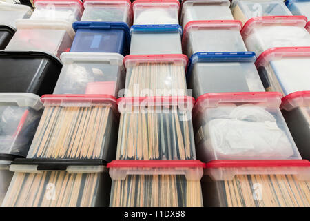 Wall of plastic file storage boxes with folders, binders and miscellaneous supplies. Stock Photo