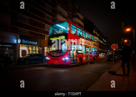 Blurred image taken at night of one of the late night last London buses on route through the city centre Stock Photo