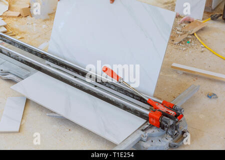 Cutting worker working with floor tile cutting industrial equipment at repair renovation work master cuts the tile Stock Photo