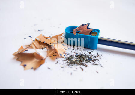 Close up of a pencil sharpened with a sharpener with pencil peels and black graphite lead waste on a white background copy space Stock Photo