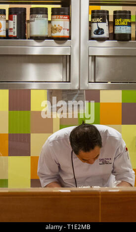 Male chef preparing food in the kitchen of restaurant Cafe Mosaic in the Carlton Hotel Singapore. Stock Photo