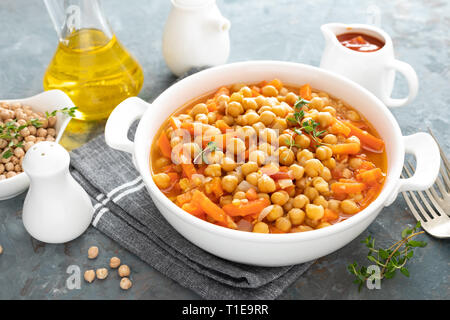 Chana Masala, spicy chickpea curry with carrot and onion in tomato sauce. Vegetarian dish for lunch. Indian cuisine Stock Photo