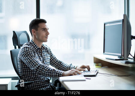 Portrait of young businessman working on computer Stock Photo