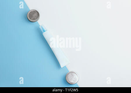 Set of blue and white cosmetic tube mockup and tins on blue and white background. Flat lay. Stock Photo