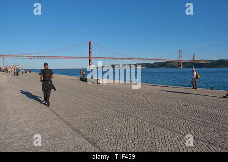 Riding electric scooter along river Tejo in Lisbon Stock Photo