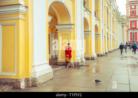 Attractive blonde in a red coat walks around the city. St. Petersburg, Russia - March 15, 2019. Stock Photo