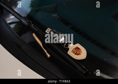 Novosibirsk, Russia - 08.01.2018: Car key remote door opener with a leather keychain from a Porsche Cayman lying on the windshield at the wipers Stock Photo