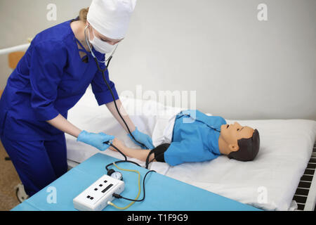 medical student measures the pressure on the dummy. Training in medical practice in the training hospital Stock Photo