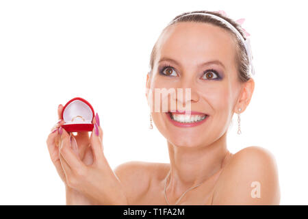 Excited happy bride holding opening engagement ring box. Surprised woman in white wedding dress isolated on white background. Stock Photo