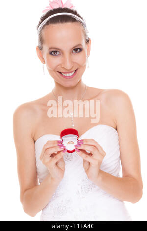 Excited happy bride holding showing engagement ring box. Surprised woman in white wedding dress isolated on white background. Stock Photo
