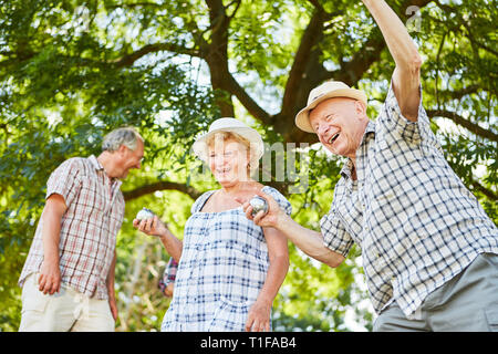 Group of seniors enjoys playing boccia or boules in the garden of the retirement home Stock Photo