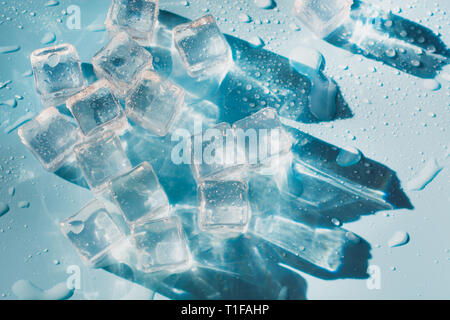 Wet ice cubes on blue background. Summer pattern. Close up. Stock Photo