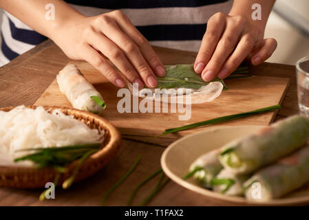 Fresh spring rolls with shrimps with cooker hands on background Stock Photo