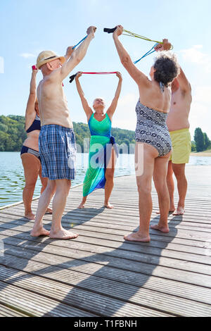 Group of seniors in a gymnastics class doing rehab exercises with the skipping rope Stock Photo