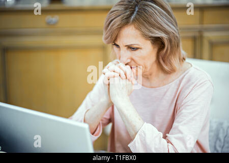 Happy woman using laptop at home Stock Photo