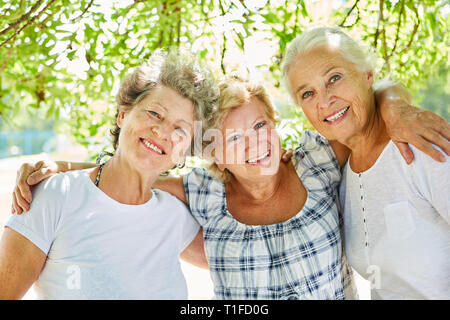 Three happy senior women as best girlfriends in summer in nature Stock Photo