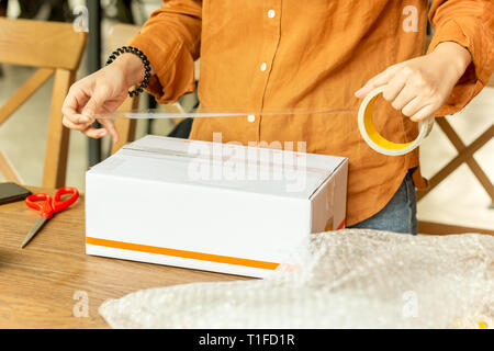 Startup small business woman owner packing cardboard box at workplace. Stock Photo