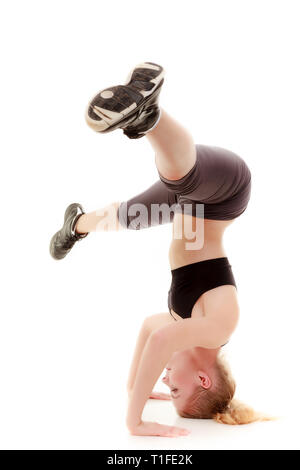 Full length young sporty woman fit fitness sport girl training doing stretching exercise standing on her head isolated on white background. Stock Photo